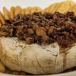 Baked brie round with brandy pecan topping.