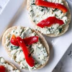 Baguette slice topped feta cheese, cilantro, and roasted red pepper.
