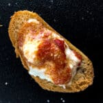 Baked ricotta with spicy roasted red pepper sauce served on crostini.