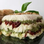 Layers of cheese, pesto, sun dried tomatoes and nuts.