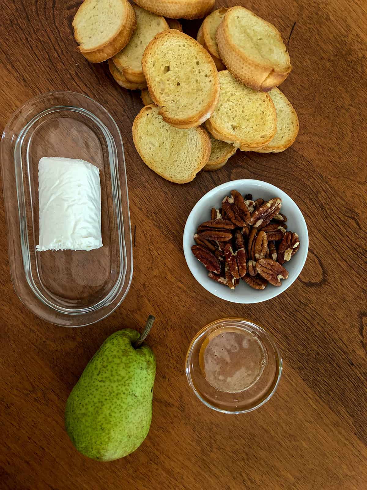 Crostini, pecans, honey, a pear, and log of goat cheese.