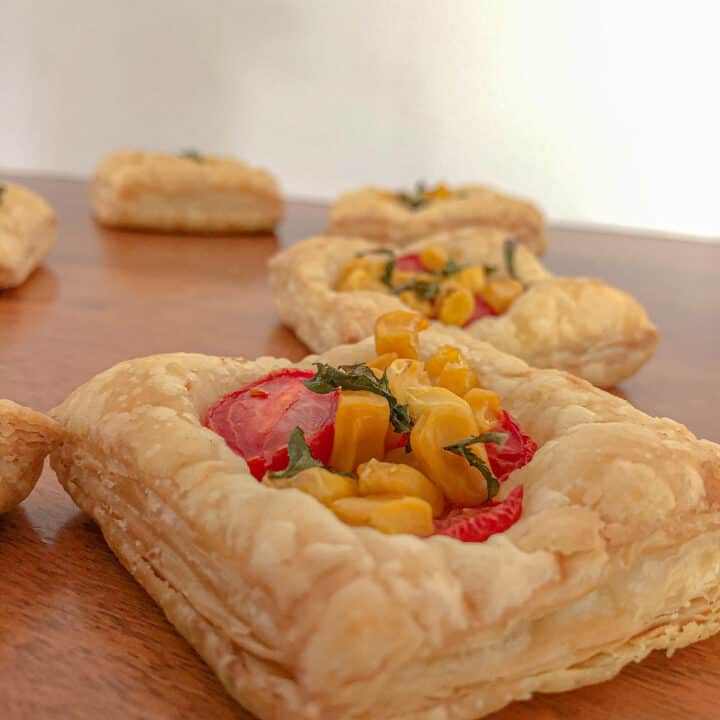 Puff pastry squares baked with tomatoes, corn, and basil.