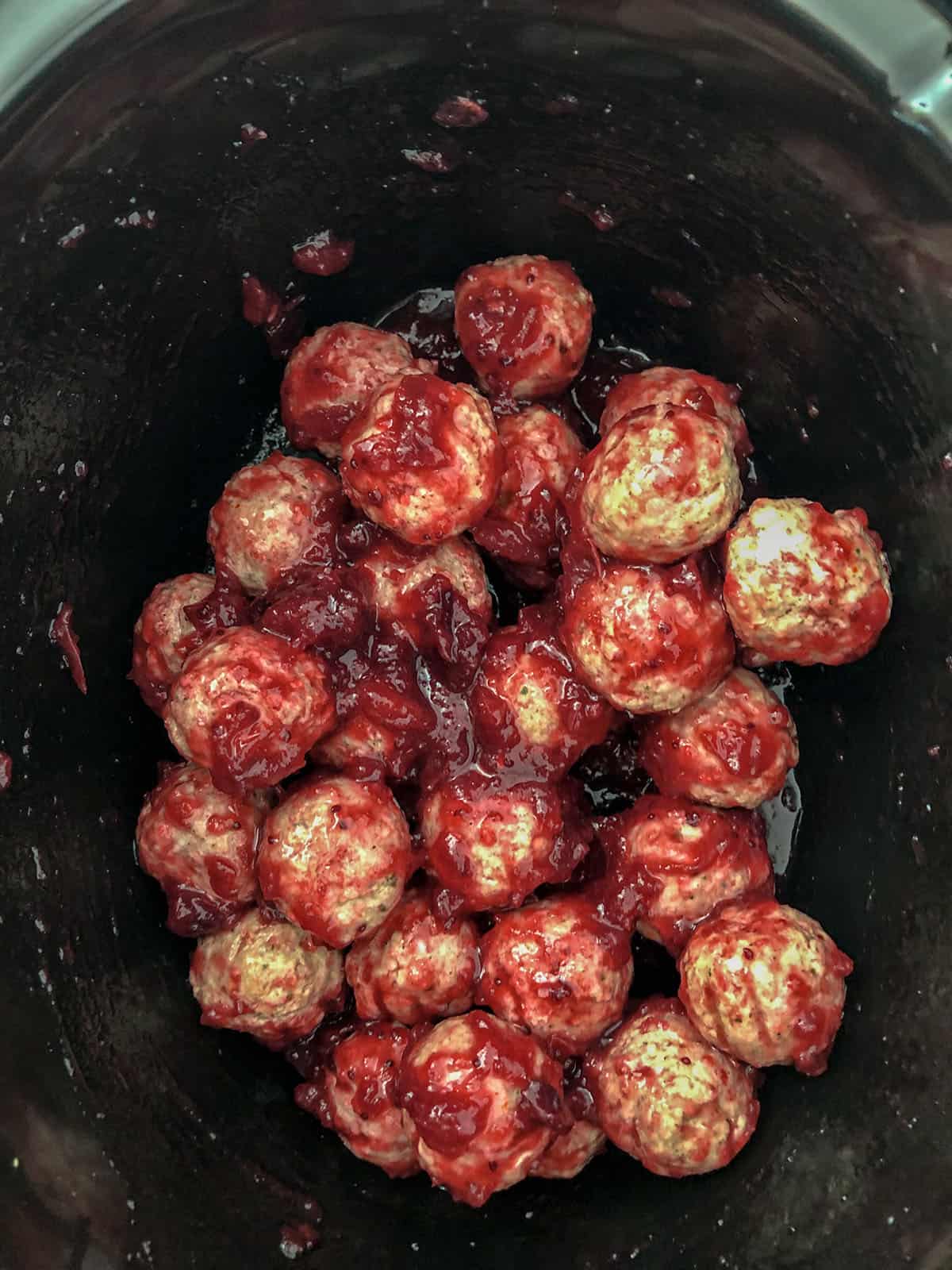 Cocktail meatballs in cranberry sauce in a crockpot.