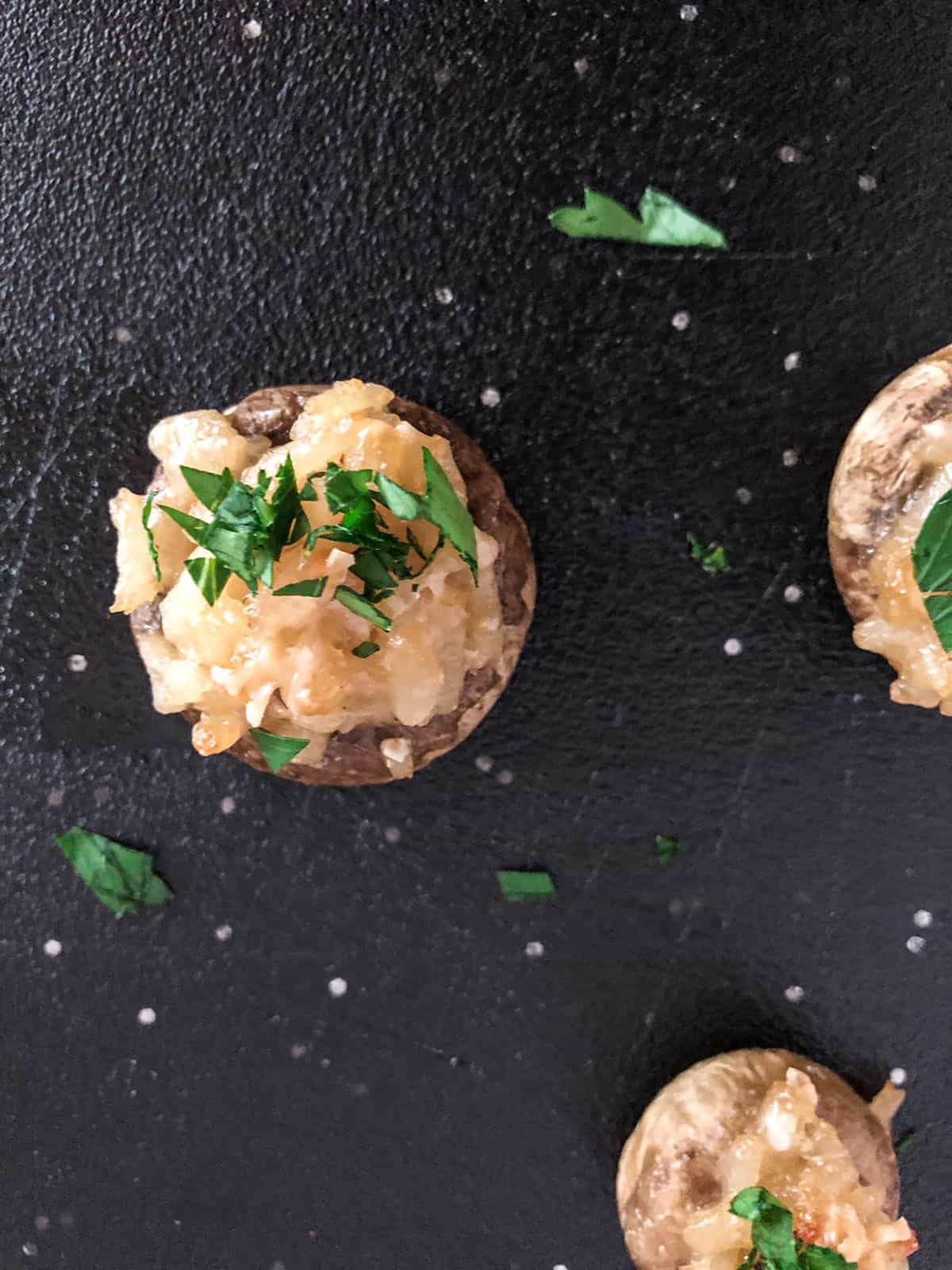Mushroom cap filled with risotto and topped with parsley.