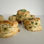Jalapeño cheddar biscuits stacked on a board.