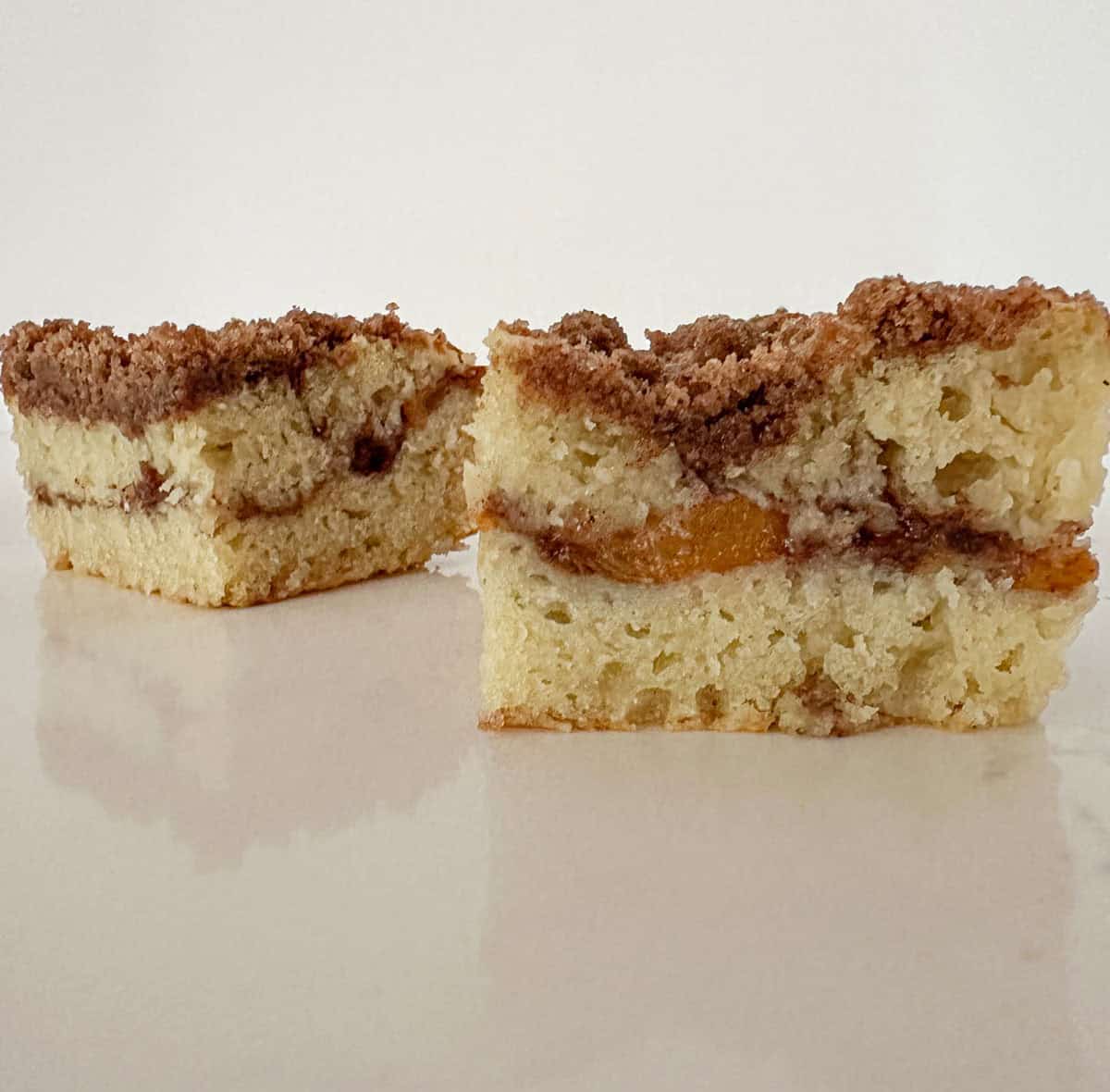 Pieces of peach coffee cake on a table.