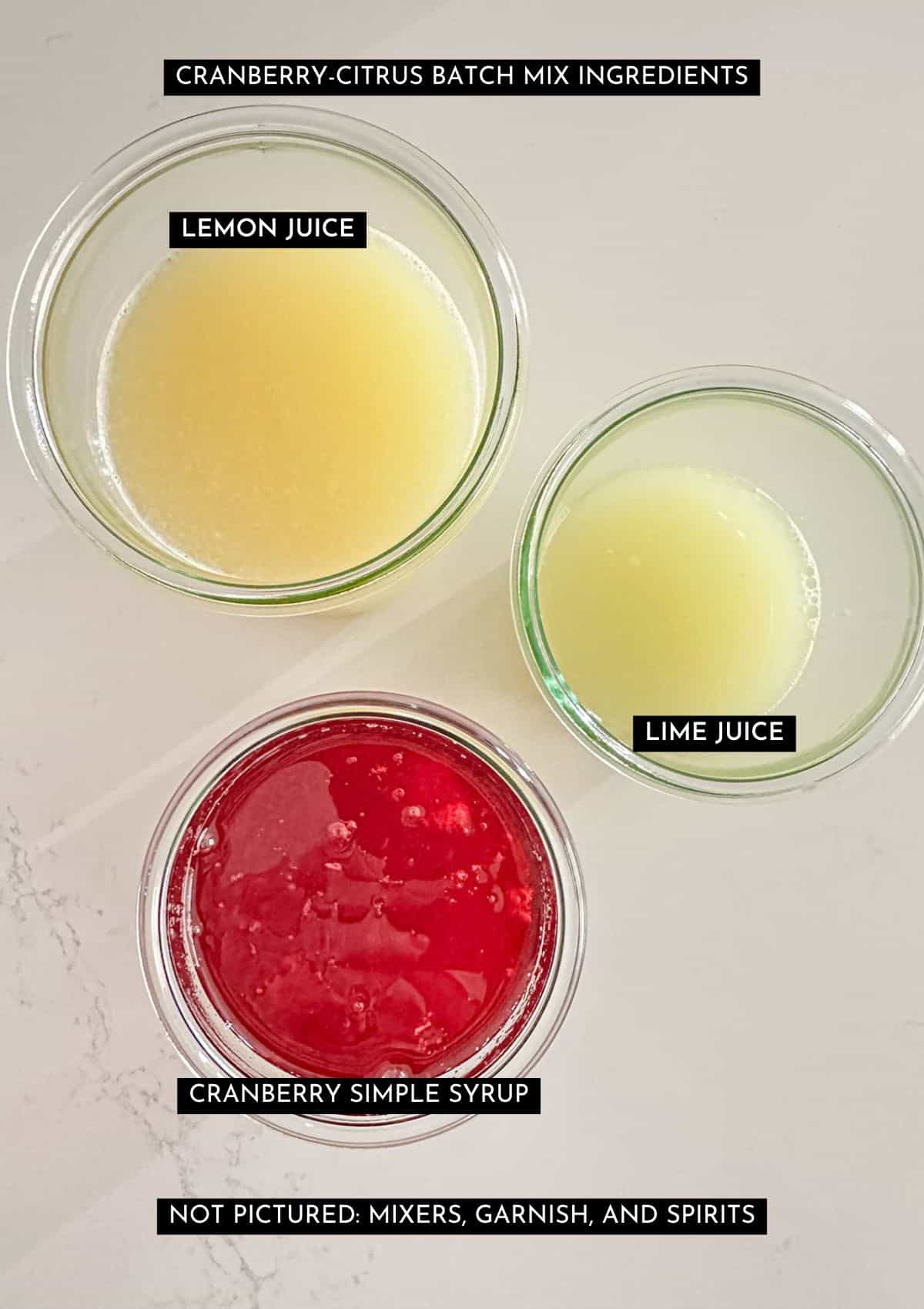 Lemon and lime juice, and cranberry simple syrup in individual jars.