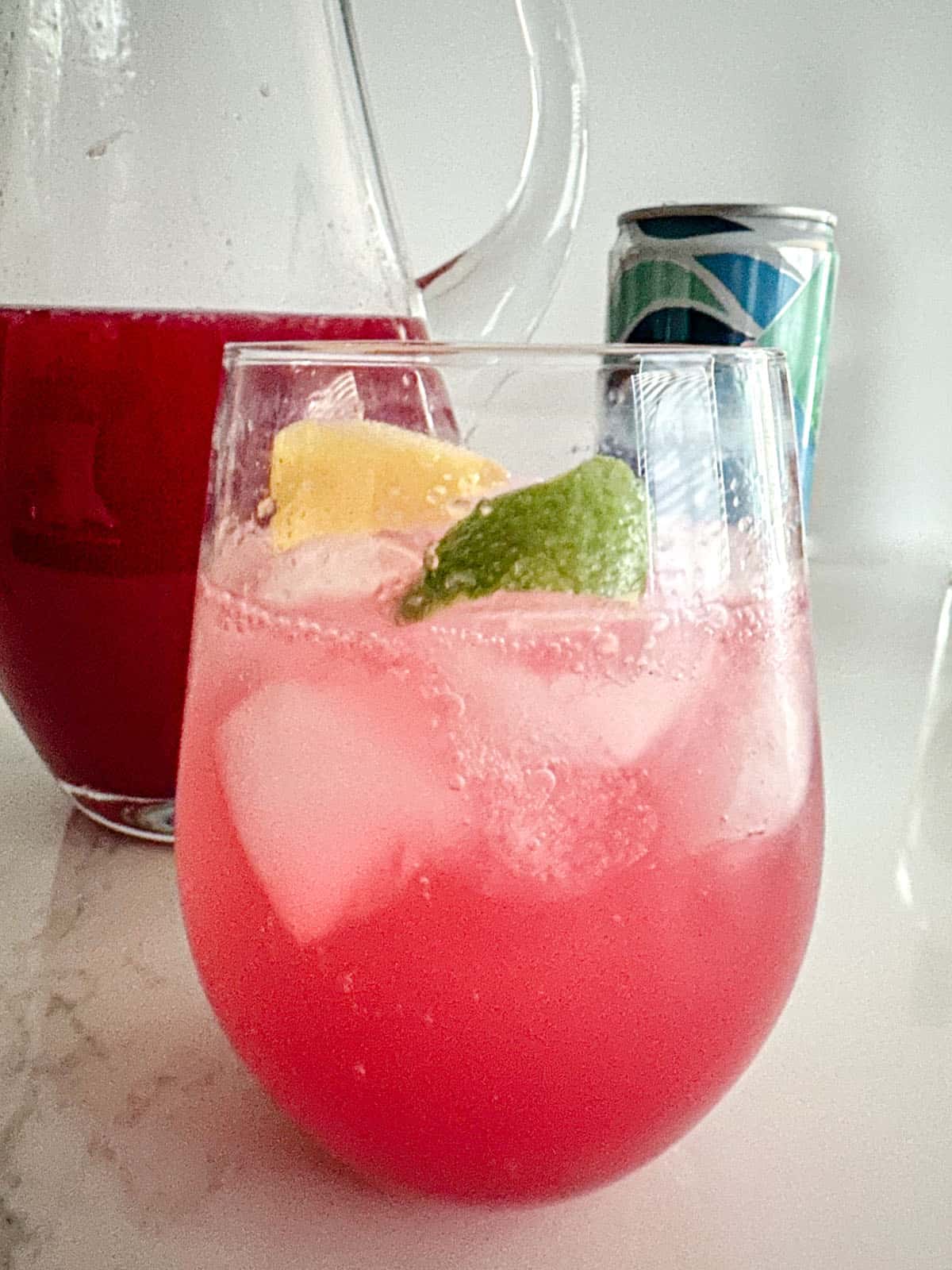 Glass with cranberry simple syrup, lemon and lime juice, and club soda.