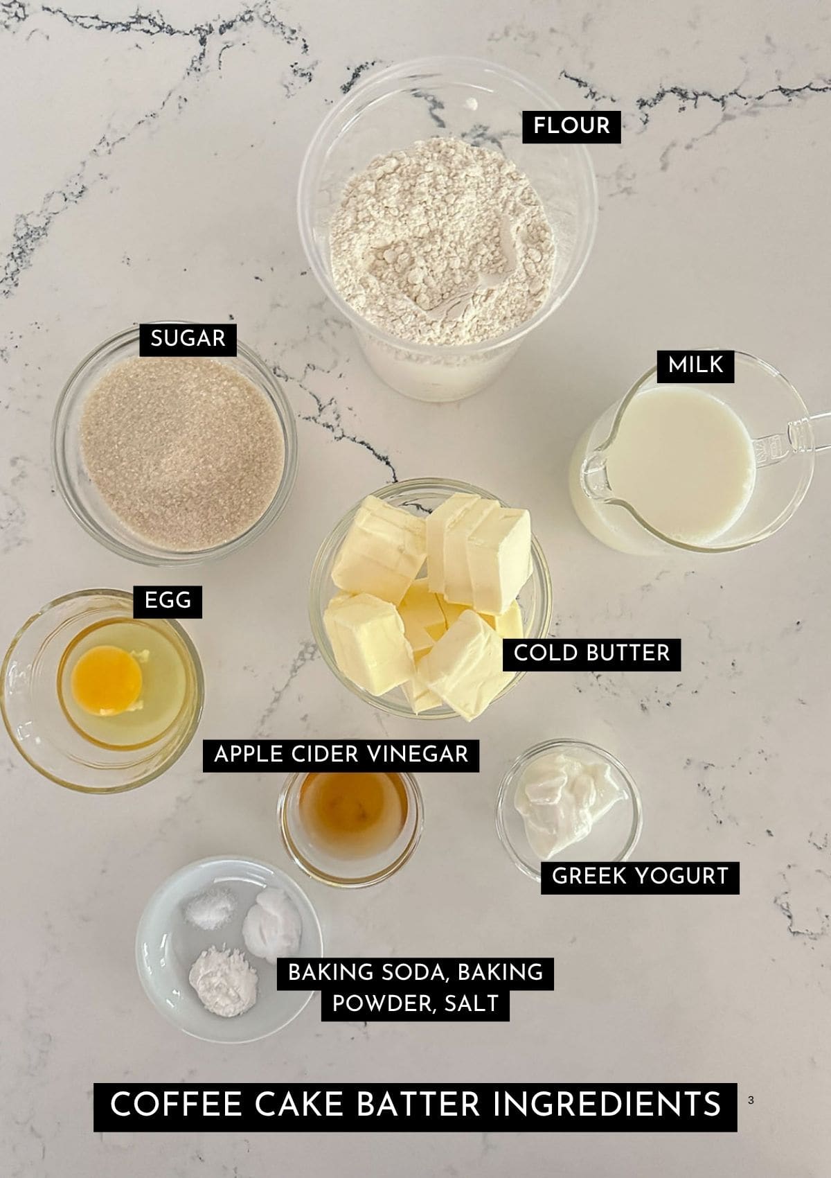 Flour, sugar, milk, butter, egg, apple cider vinegar, Greek yogurt, baking soda, baking powder, and salt in individual dishes.
