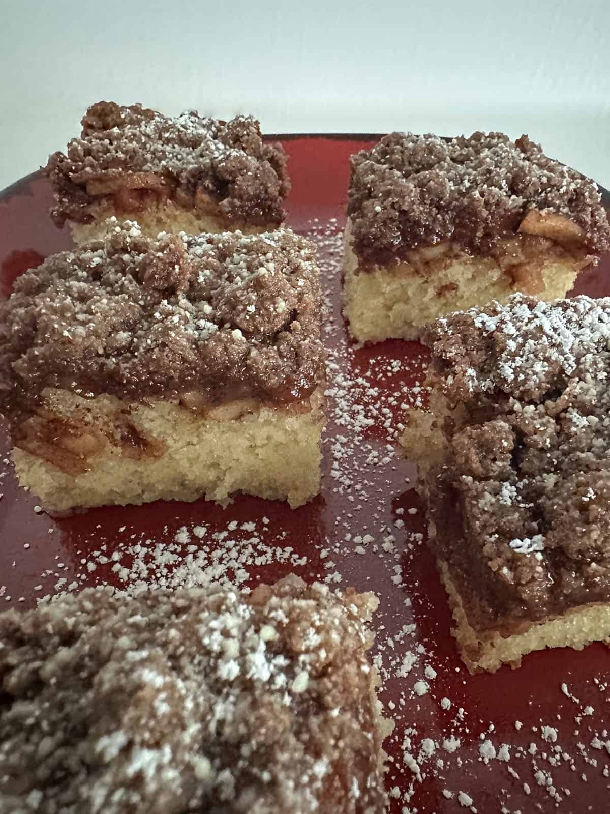 Platter of apple coffee cake dusted with powdered sugar.