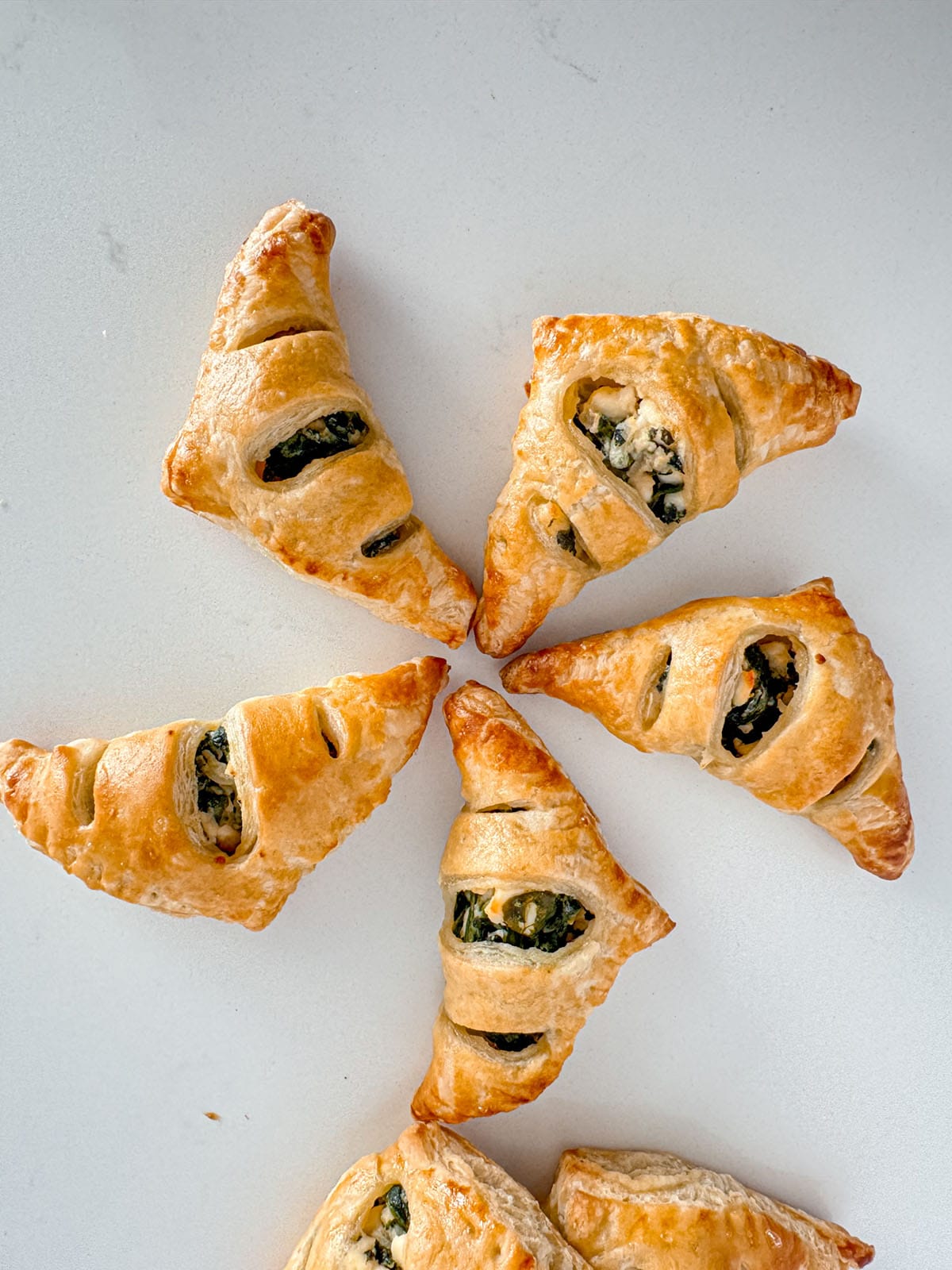 Baked triangles of puff pastry filled with spinach and feta cheese.