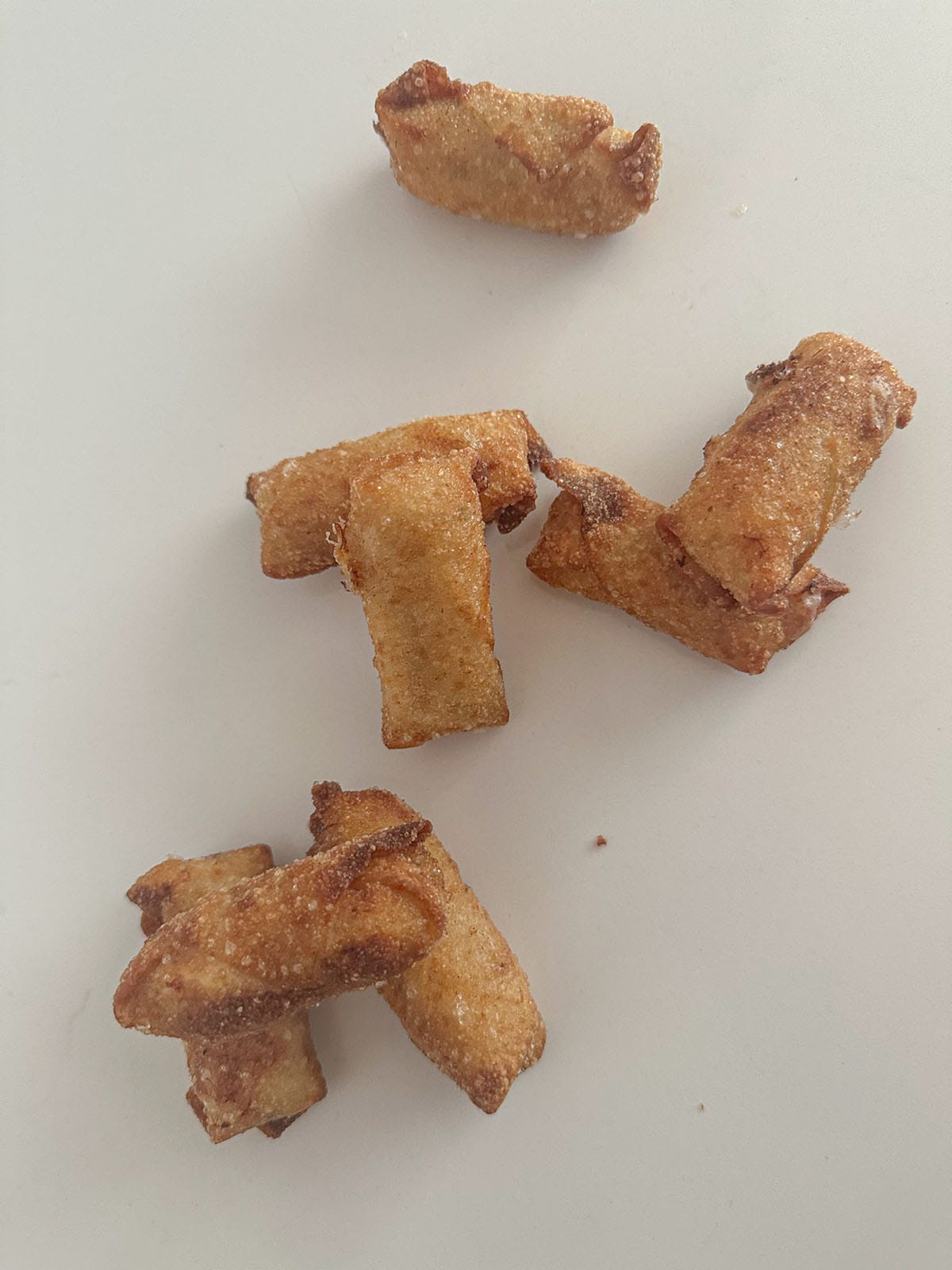 Fried mini crab egg rolls on a table.