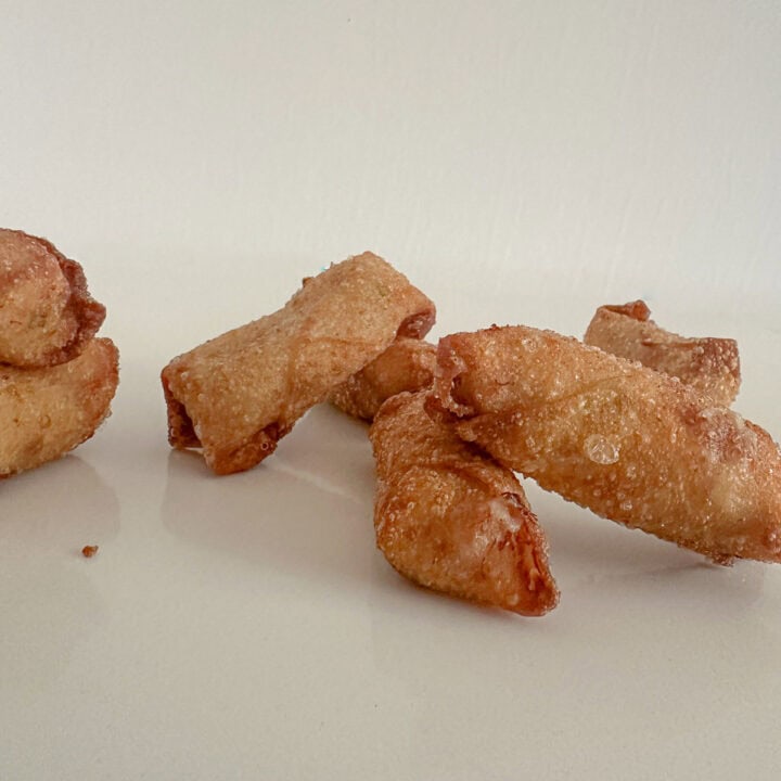 Deep fried mini crab egg rolls on a table.