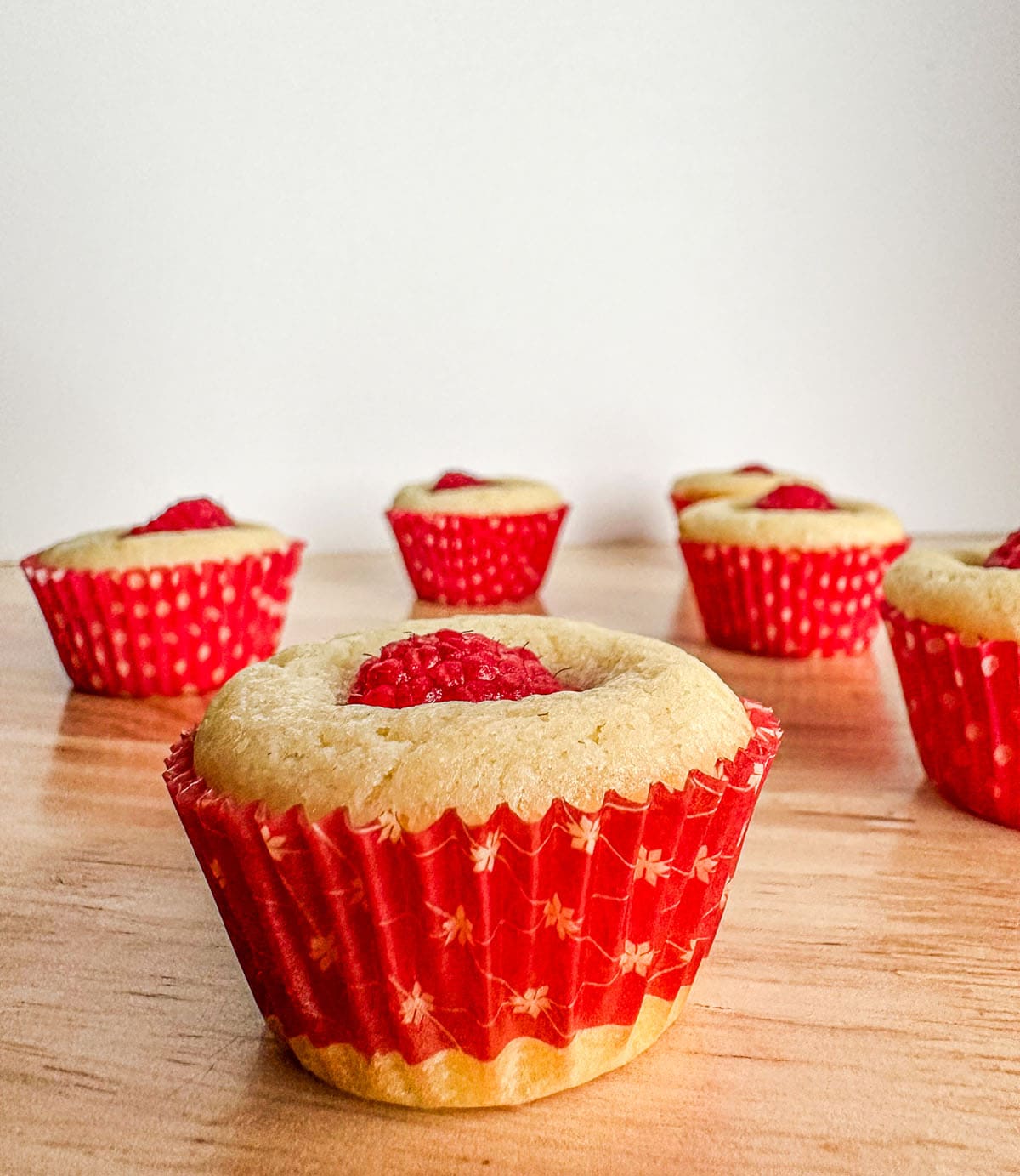 Raspberry muffins on a tabletop.