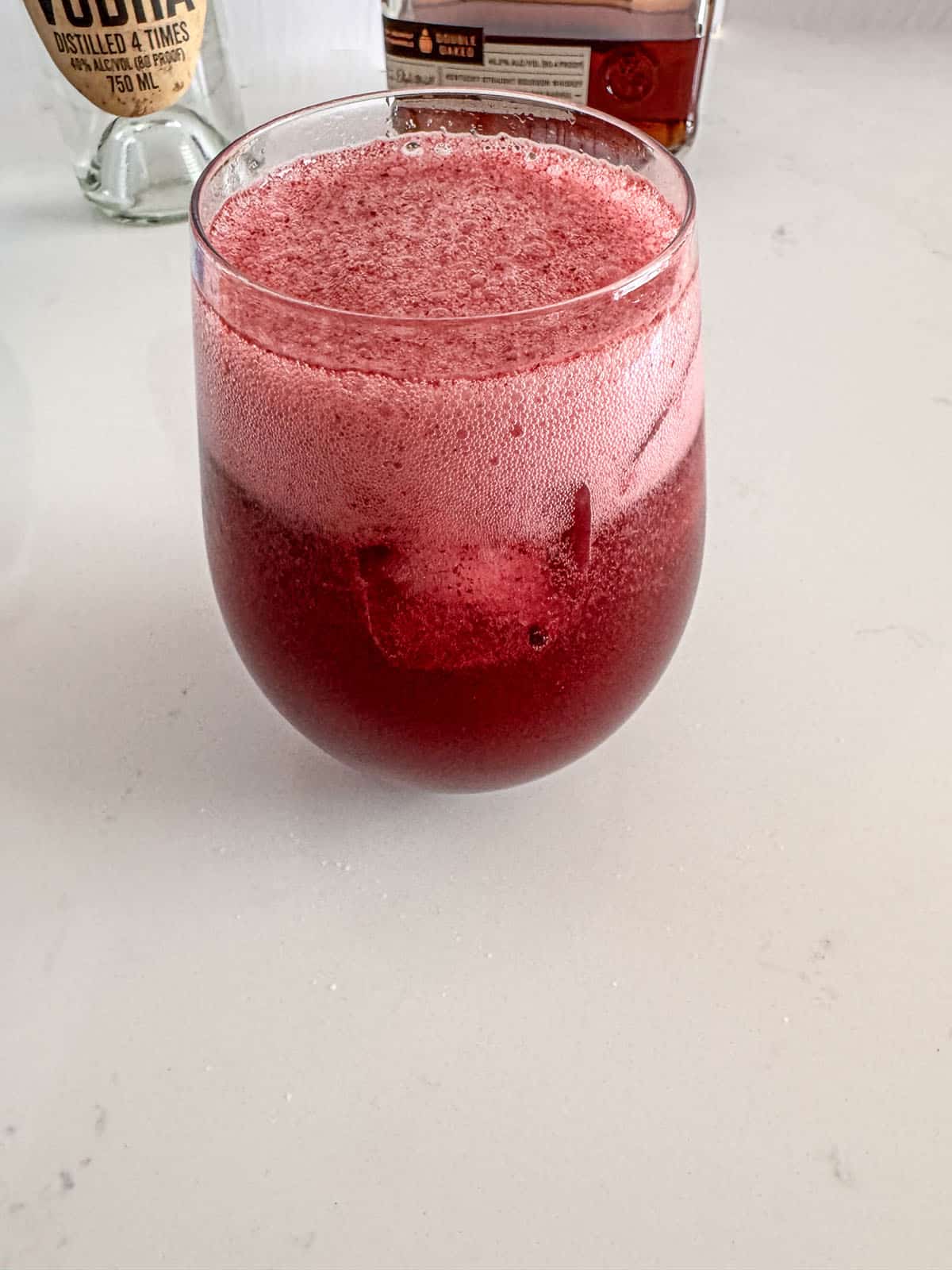 Glass with blueberry puree, mint simple syrup, lime juice, ginger beer, club soda, and ice.