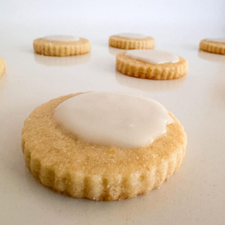 Iced lemon shortbread cookies on table.
