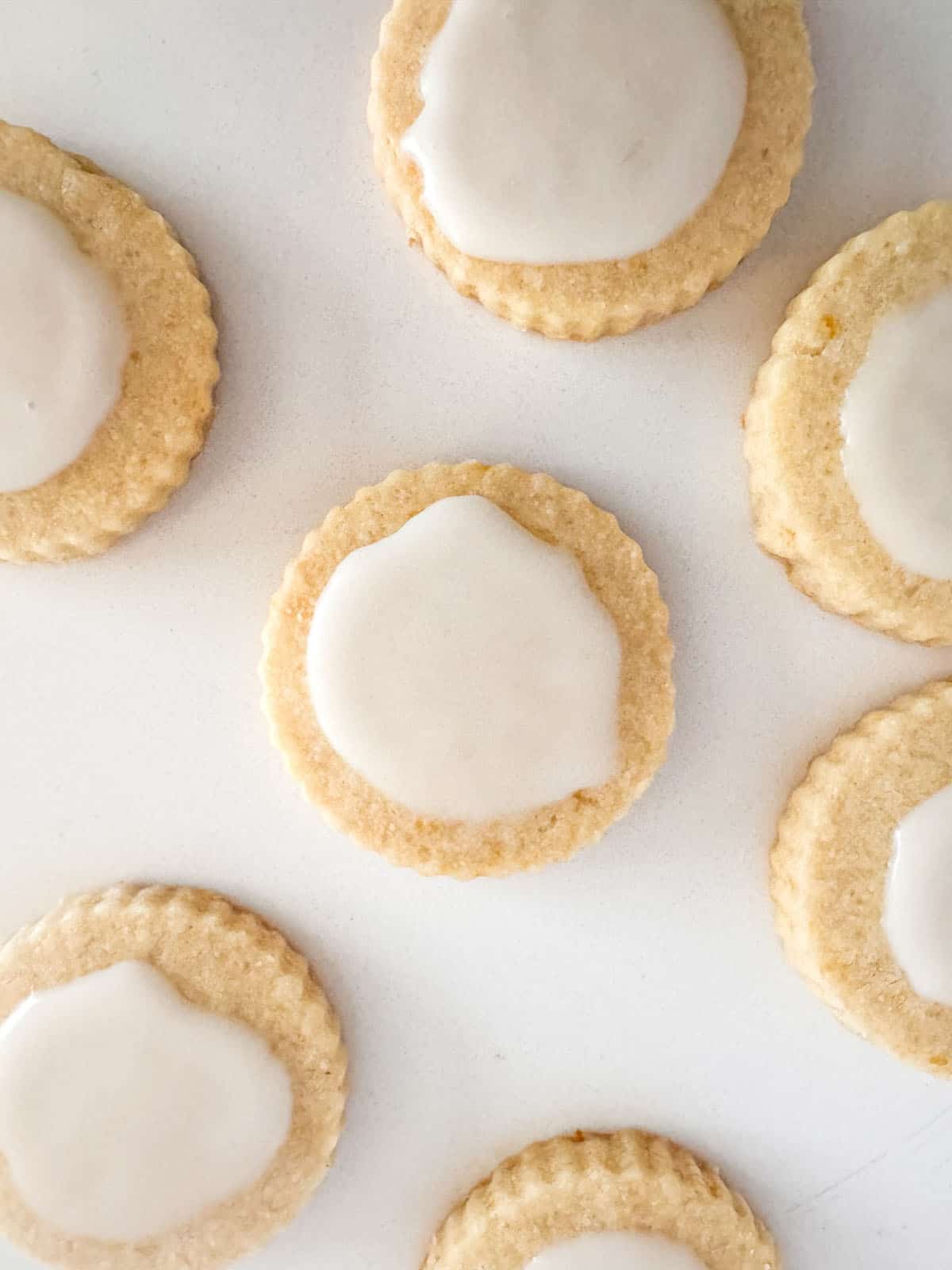 Lemon shortbread cookies with lemon glaze on table top.