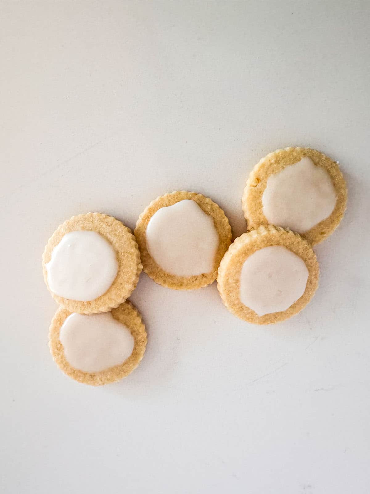 Lemon glazed lemon shortbread cookies on table top.